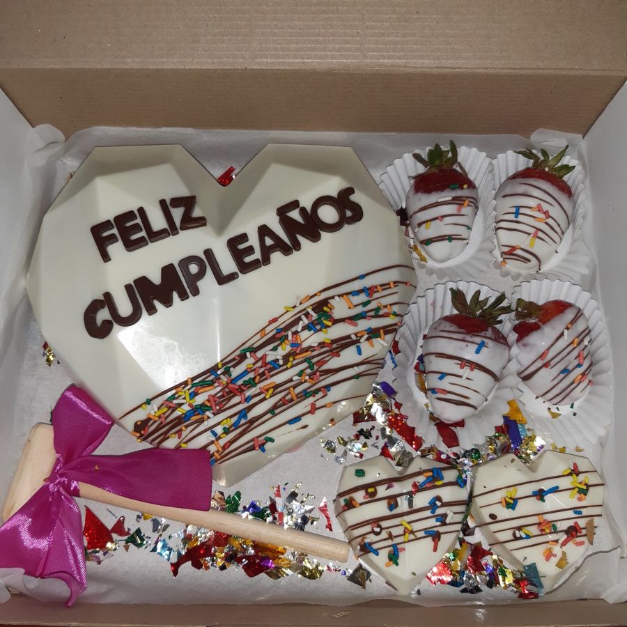 Corazón de chocolate blanco que dice Feliz cumpleaños, con fresas y corazones